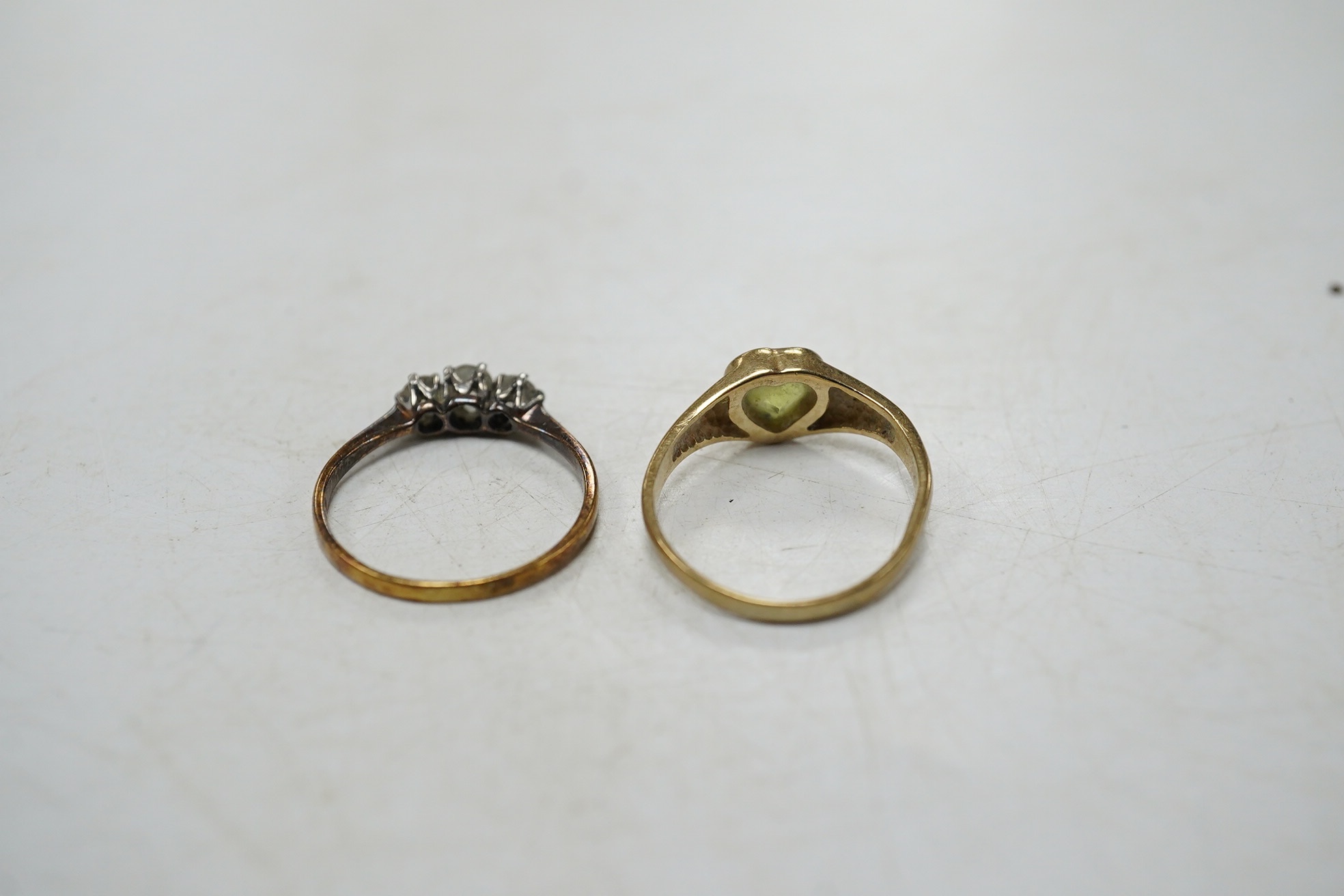 An 18ct and three stone diamond set ring, size G and one other 9ct gold and heart shaped green stone set ring. Condition - poor to fair